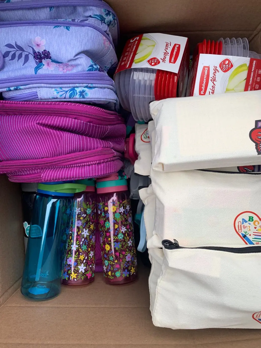 Packed lunch bags, water bottles and snacks inside a delivery box