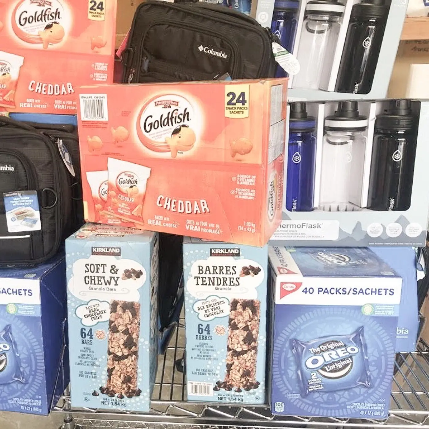 Boxes of snacks, lunch bags and water bottles stacked for Project Lunchbox