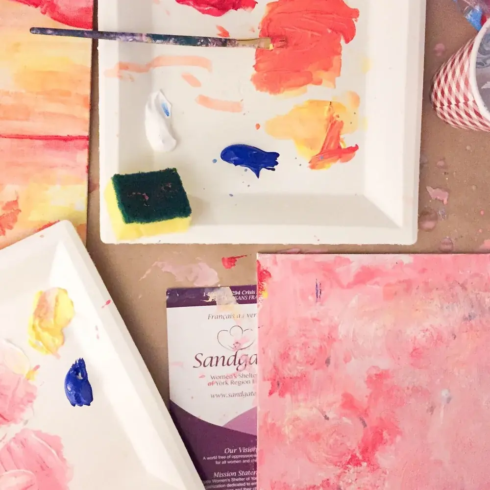 Paint palettes and colourful abstract paintings in progress