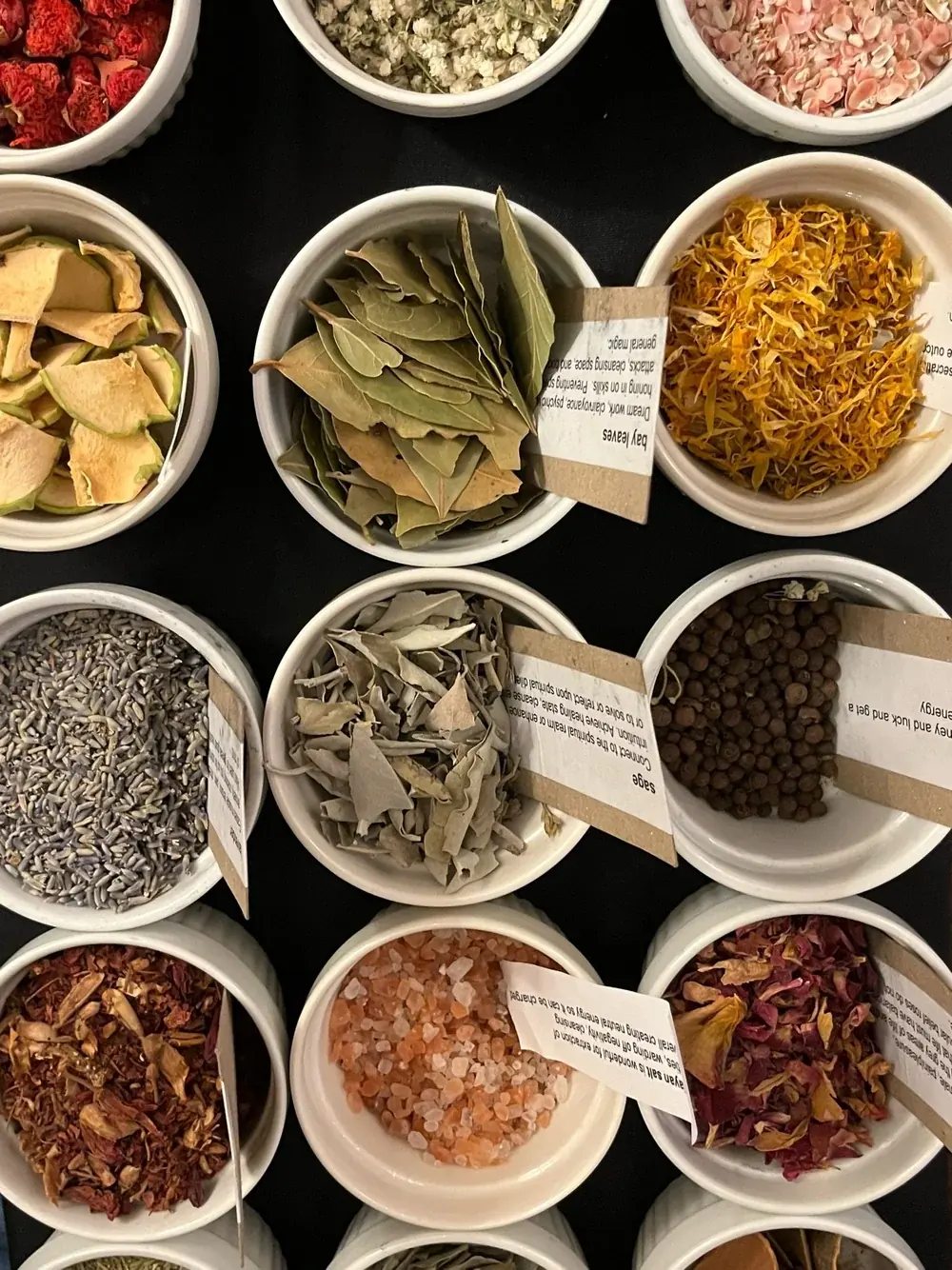 Bowls of dried herbs and flowers for candle blending