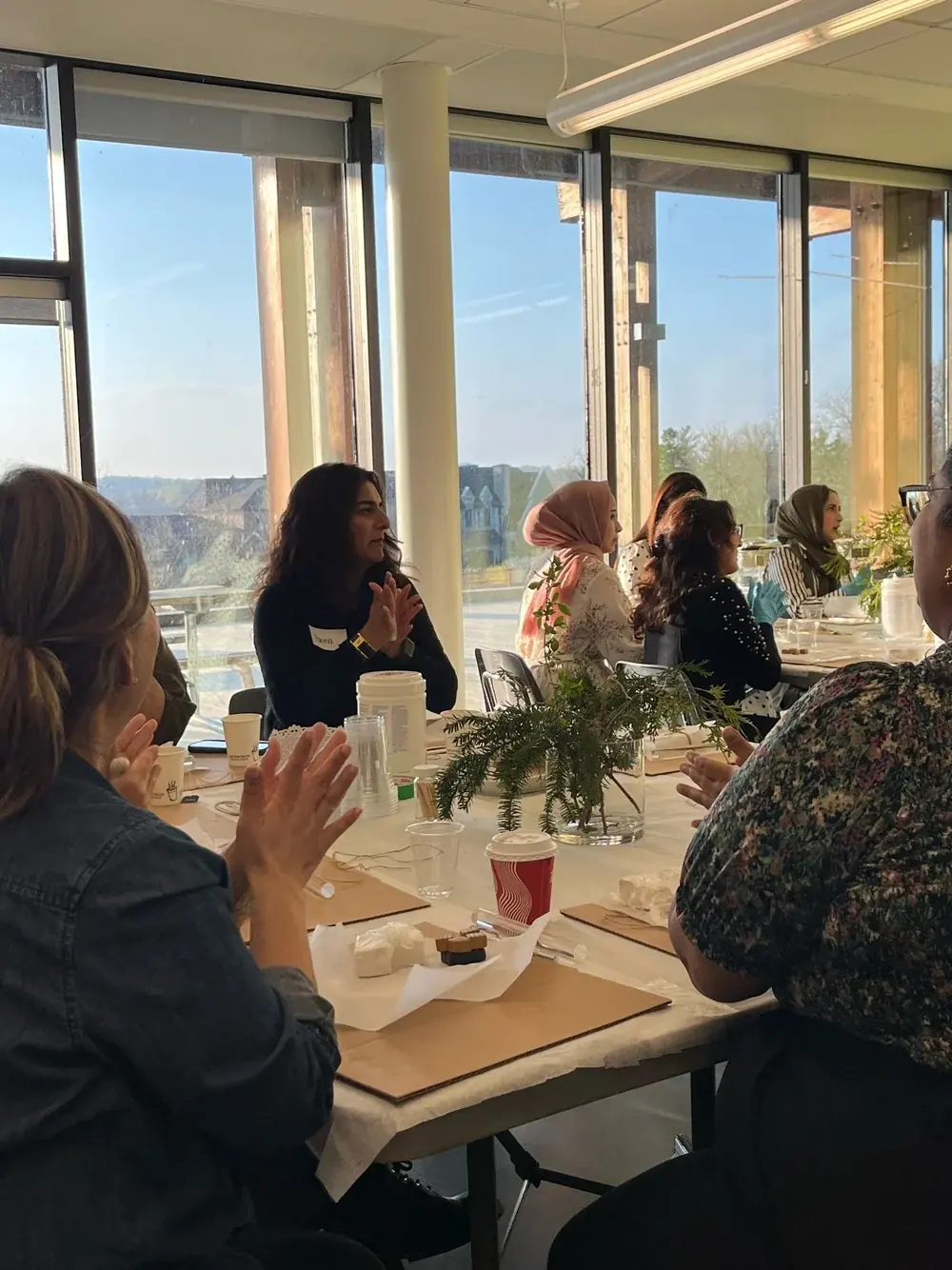 Guests seated at tables beside large windows with a view of trees