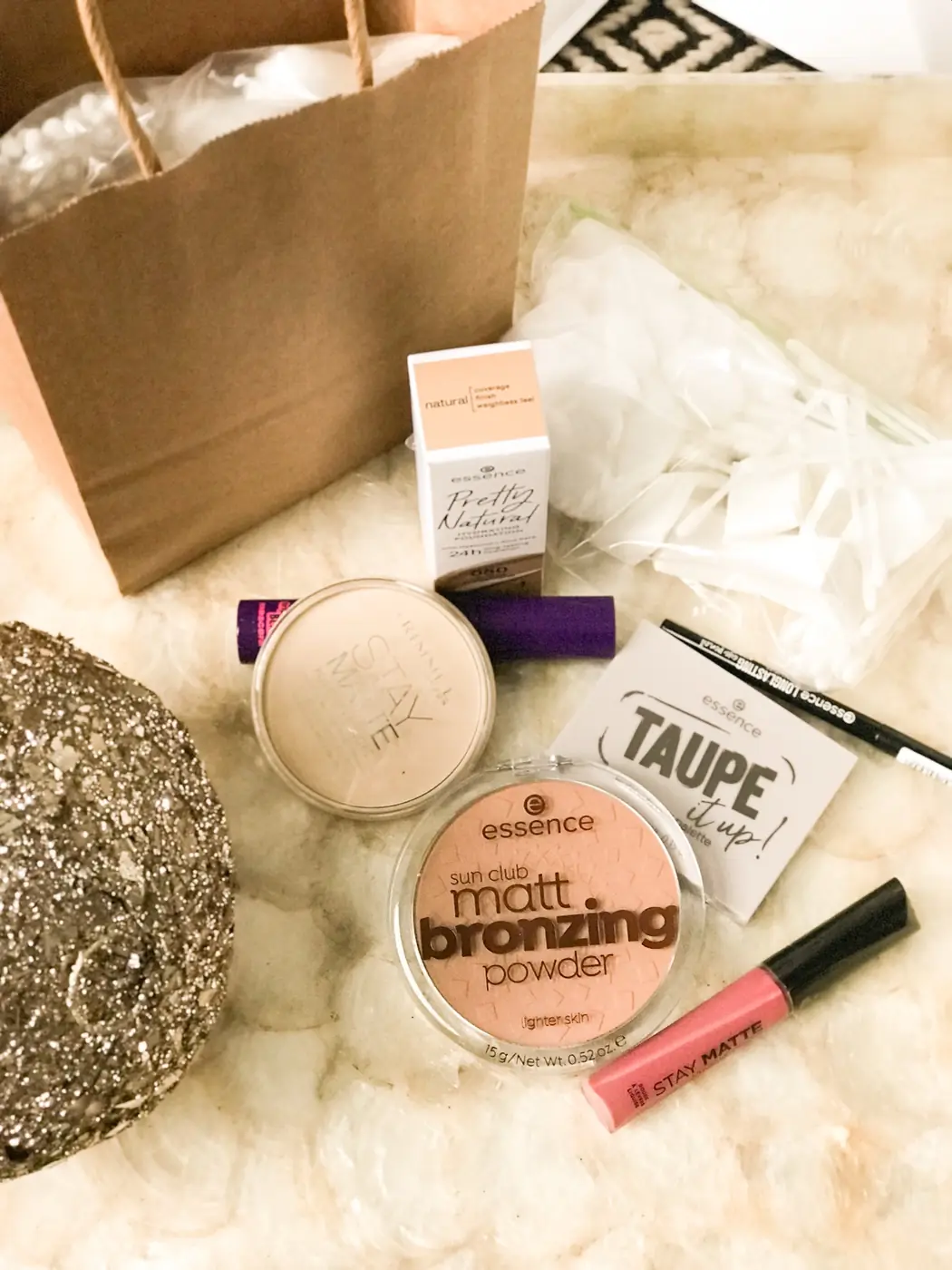 A self-care kit with makeup and skincare items in a kraft gift bag