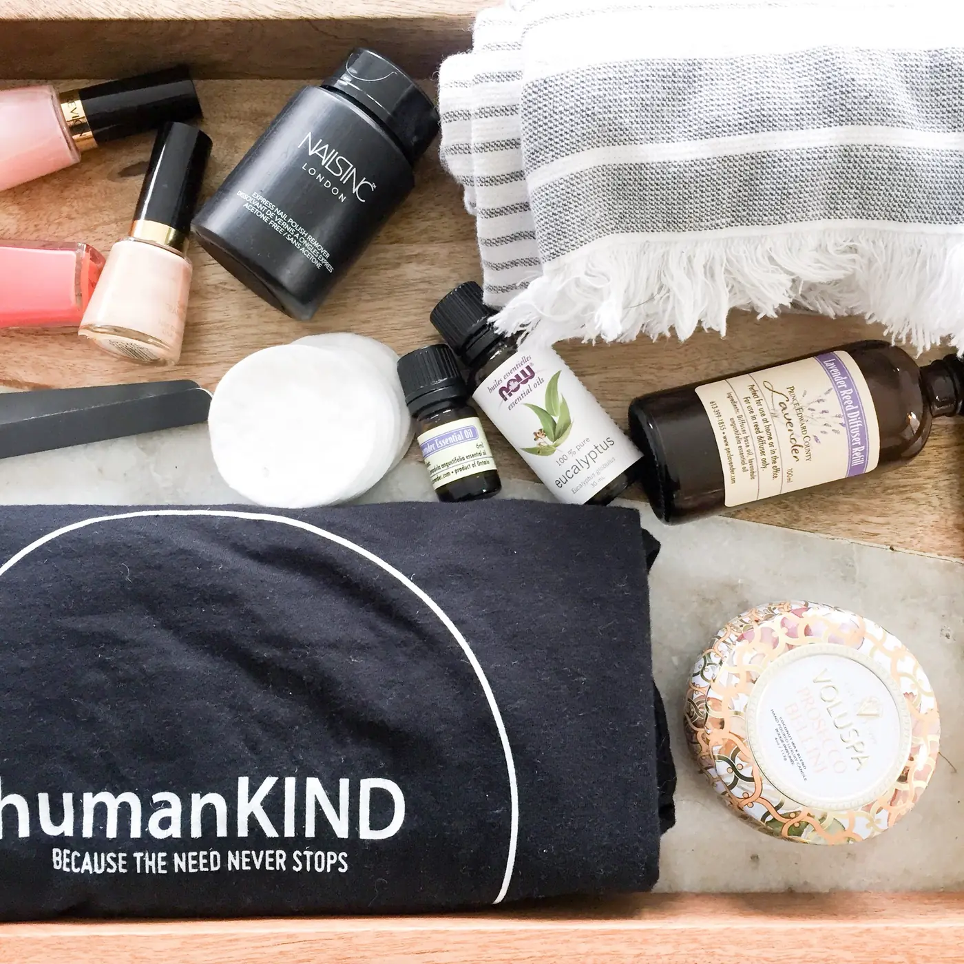 A humanKIND tote printed with Because the need never stops, surrounded by self-care items