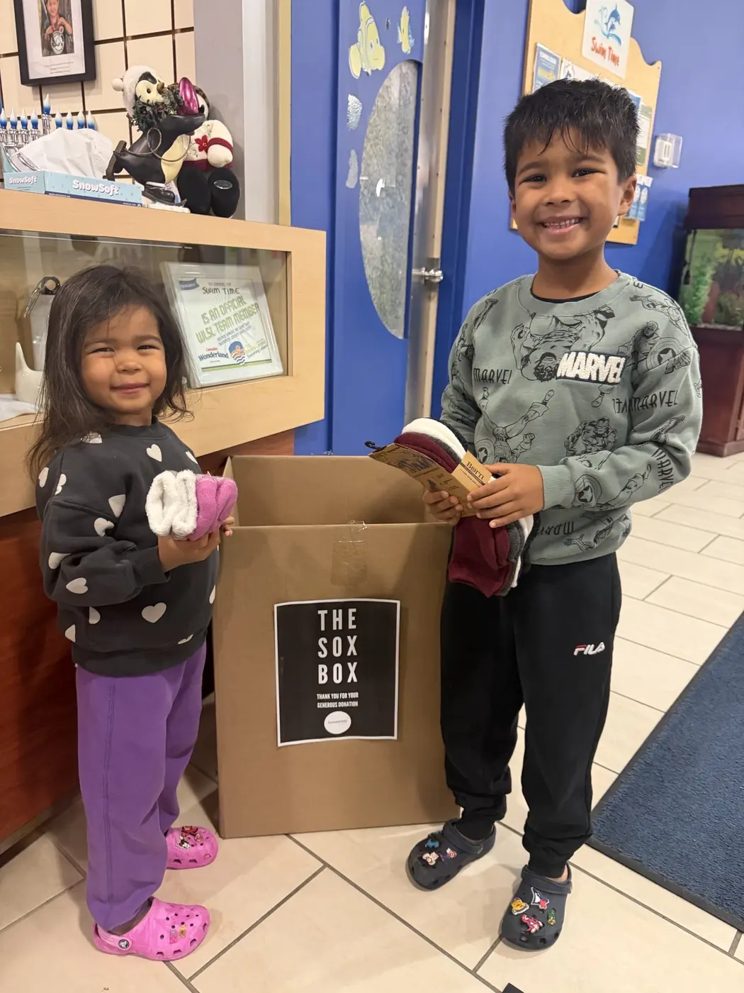 Two children with a Sox Box collection box