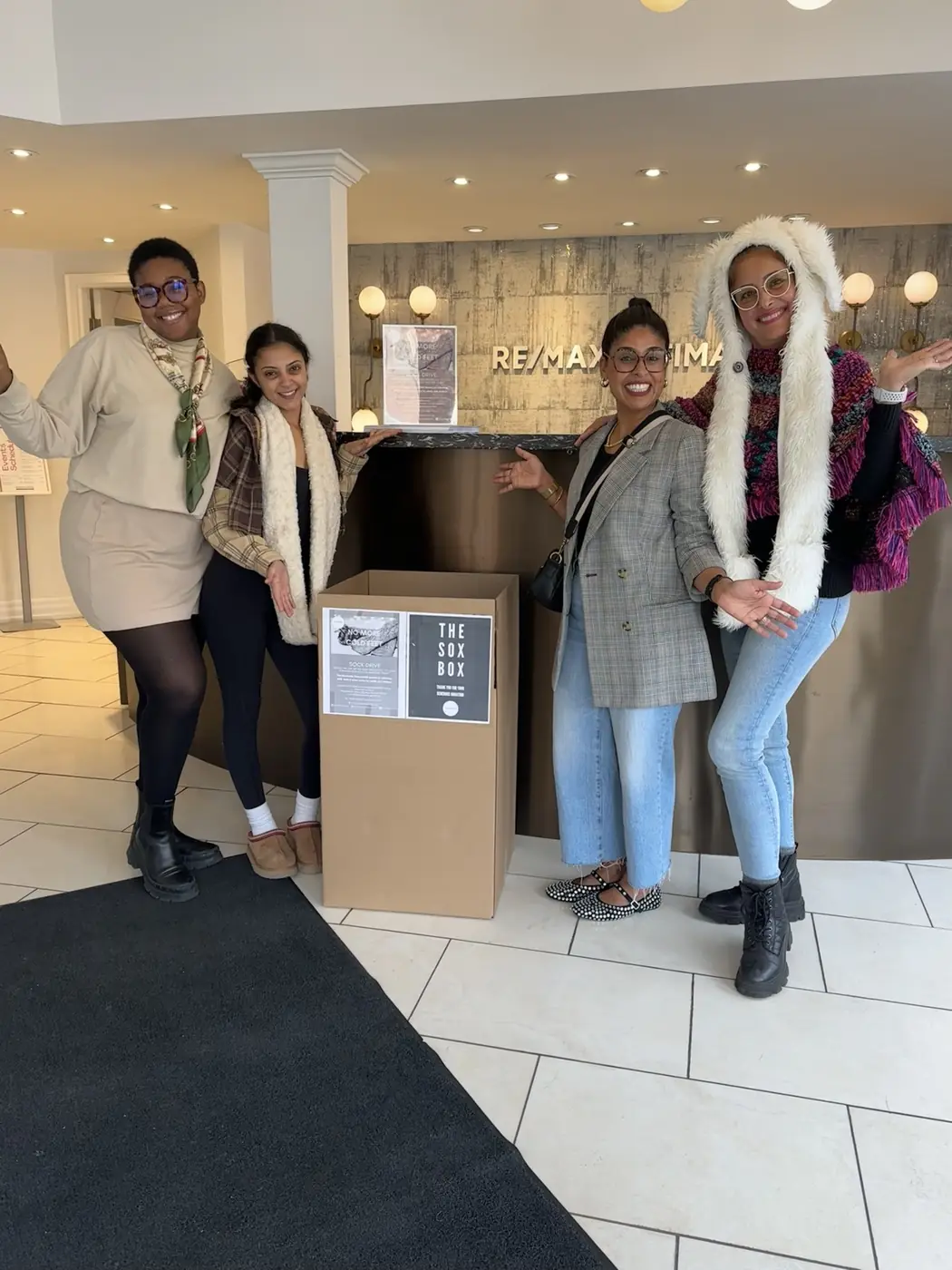 People posing beside a Sox Box at a local business